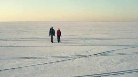 The two backpackers walking through the icy snow field Stock Footage 189344795