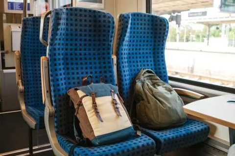 Two backpacks on the seats in the train Stock Photos