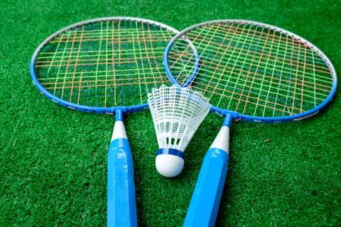 Two badminton mini rackets with white shuttlecock on the green background, ac Stock Photos