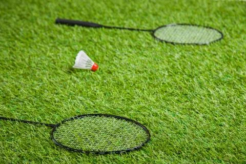 Two badminton rackets lying with white shuttlecock Stock Photos