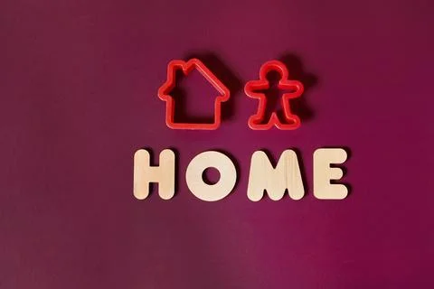 Two baking pans in the shape of a house and a person and the inscription Home Stock Photos