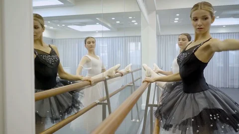Two ballerinas in ballet tutu perform exercises at machine. Stock-Footage 83871269