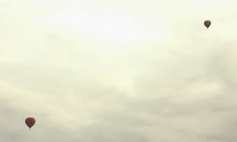 Two balloons in a pale cloudy sky Photos