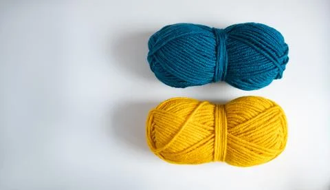 Two balls of yellow blue thread for knitting or crocheting on a light background Stock Photos