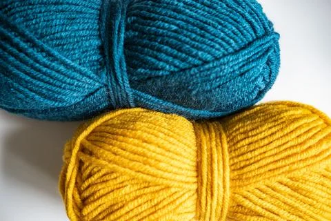 Two balls of yellow blue thread for knitting or crocheting on a light background Stock Photos