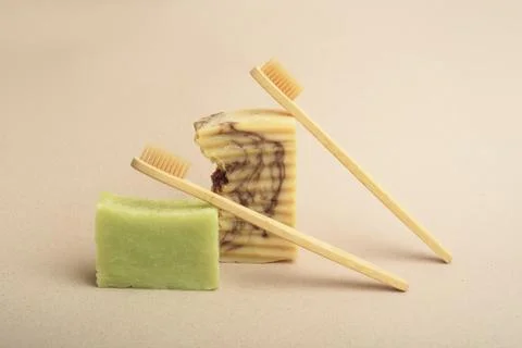 Two bamboo toothbrushes and two bars of handmade soap. Stock Photos
