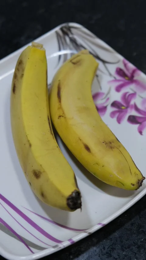 Two Bananas on Plate Vertical 4K Stock Footage 331621214
