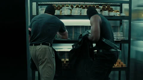 Two bank robbers stealing piles of money and gold bars and putting them in .. Stock Footage 262502853