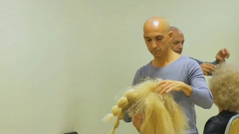 Two Barbers or stylist makes styling of curly hair of model by hairdresser in Stockbeeldmateriaal 70796871