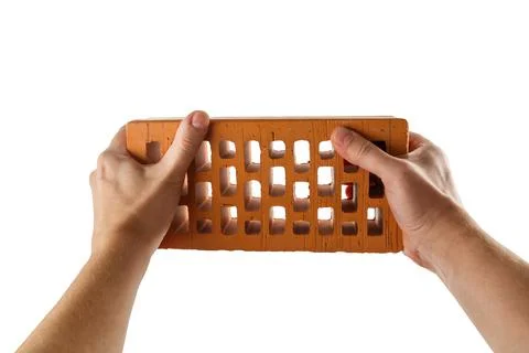 Two bare caucasian hands holding orange perforated clay brick - isolated on 库存照片