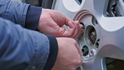 Two bare caucasian hands inserting and screwing in heagonal bolts Stock Footage 164568793