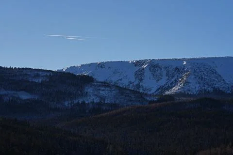 Two barley visible planes flying over the snowy mountains. Stock Photos