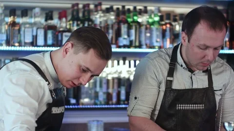 Two barmanan working and discussing something at counter in bar Vídeos de archivo 76596497
