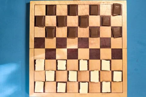 Two bars of chocolate on a chessboard Stock Photos
