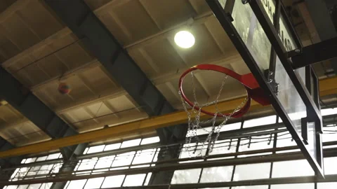 Two basketball balls trying to get into a red hoop with a chain net Stock Footage 201146839