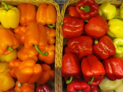 Two baskets with multi-colored yellow, orange and red peppers. Stock Photos