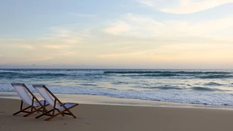 Two beach chairs on the beautiful sunset beach. Видео 93014920