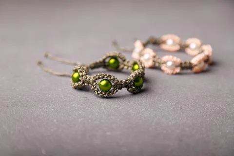 Two beaded bracelets from macrame yarn on grey background. Soft focused shot. Stock Photos