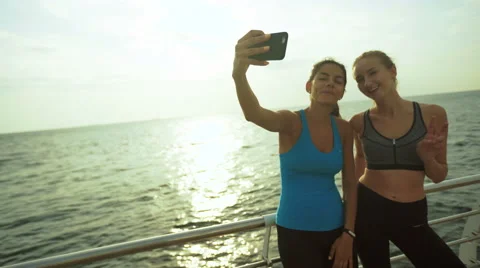 Two beautiful active ladies taking pictures after morning jogging Stock Footage 68851895