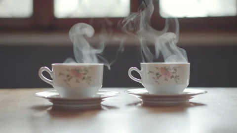 Two beautiful antique cups with steamy hot coffee on a vintage wooden table Stock Footage 221763720
