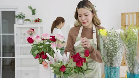 Two beautiful Asian florists work together in her own shop. Stock Footage 244661973