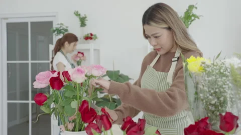 Two beautiful Asian florists work together in her own shop. Video stock 244699308