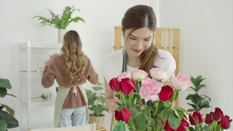 Two beautiful Asian florists work together in her own shop. Video stock 244701220