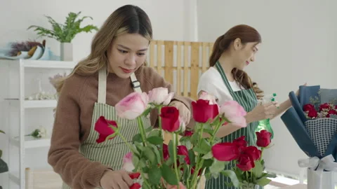 Two beautiful Asian florists work together in her own shop. Video stock 244928566