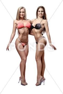Two beautiful athletic girl wearing bikini posing over white background Stock Photos
