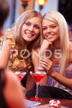 Two beautiful blond friends sitting at cafe Stock Photos
