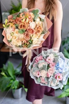 Two beautiful bouquets of mixed flowers in woman hand. Floral shop concept Stock Photos