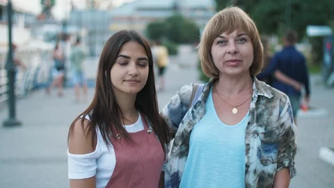 Two beautiful brunette and blond ladies looking at camera in the evening on the Vidéo 113483101