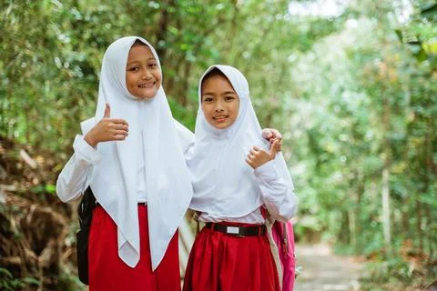 Two beautiful elementary students standing together with thumbs up Stock Photos