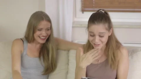 Two beautiful excited women using tablet pc in the living room Stock Footage 40341127