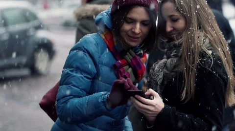 Two beautiful girlfriends looking at smartphone during winter in the city HD Stock Footage 46320311