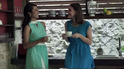 Two beautiful girlfriends talking in the kitchen at home HD Stock Footage 54903393