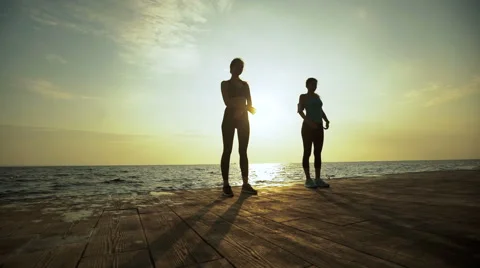 Two beautiful ladies training in the evening near the beach Stock Footage 68804622