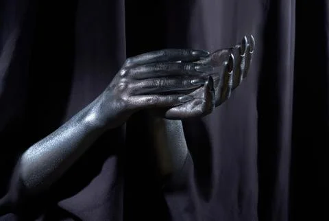 Two beautiful man's hands in silver paint on a black background Stock Photos