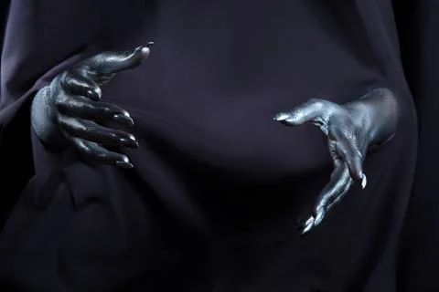 Two beautiful man's hands in silver paint on a black background Stock Photos