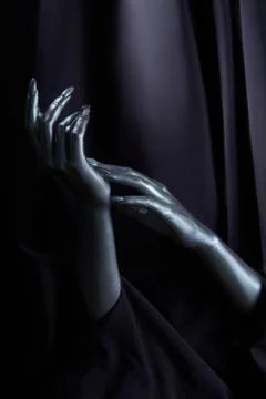 Two beautiful man's hands in silver paint on a black background Stock Photos