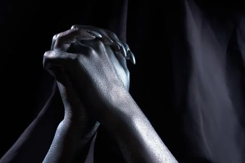 Two beautiful man's hands in silver paint on a black background Stock-Fotos