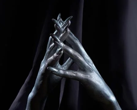 Two beautiful man's hands in silver paint on a black background Stock Photos