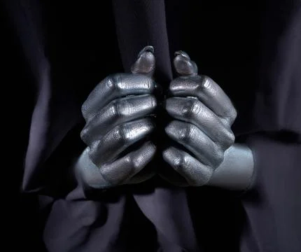 Two beautiful man's hands in silver paint on a black background Stock Photos