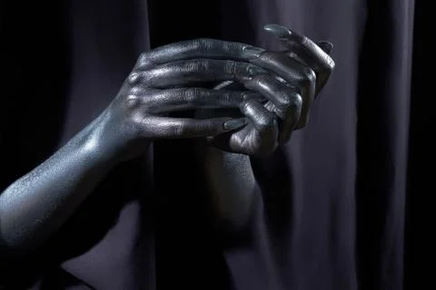 Two beautiful man's hands in silver paint on a black background Stock Photos