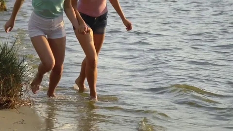 Two beautiful models  running along the shore of a beach in slow motion Stock Footage 82382393