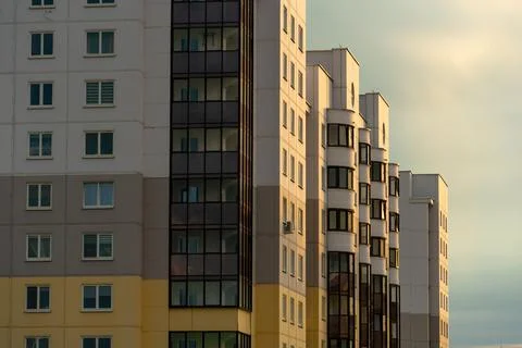Two beautiful modern multi-storey buildings on the background of gray rainy c Stock Photos