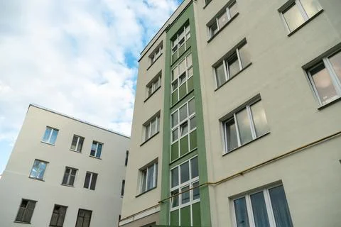 Two beautiful modern multi-storey buildings on the background of gray rainy c Stock Photos