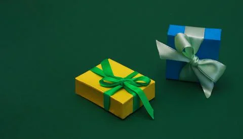 Two Beautiful multicolored gift boxes on green paper background. Stock Photos