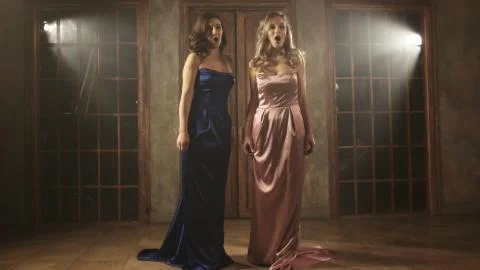 Two beautiful opera singers in long dresses Stock Photos