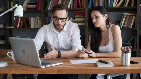 Two beautiful students brainstorm work by discuss with desktop in trendy loft cl Video stock 199491599